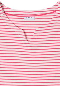 Chemise rayée blanche et rose avec un petit col en V et un détail élastique sur les épaules, avec une étiquette indiquant "CECIL" à l'intérieur du col.