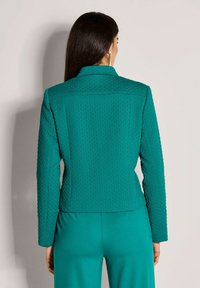 Teal structuur blazer met een getailleerde pasvorm, lange mouwen en een scherpe kraag, met een subtiel patroon en een gladde stofafwerking.