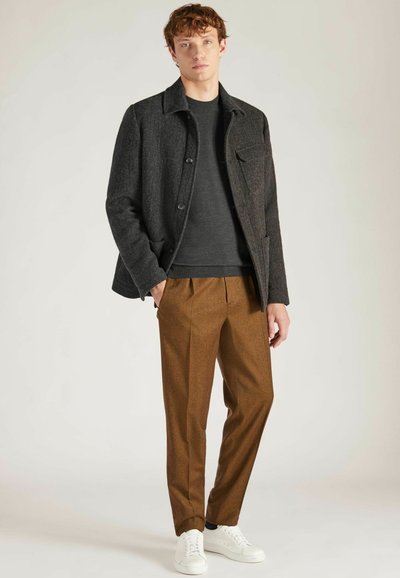 Dunkelgraue Wollmischung Jacke, anthrazitfarbener Rundhalspullover, braune gefaltete Hose und weiße Sneaker. Einfaches Design, entspannte Passform, subtile Texturen.