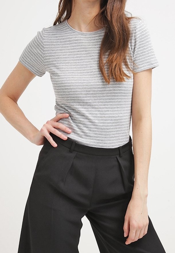 Camiseta de manga corta con rayas grises y blancas, cuello redondo, combinada con pantalones negros de talle alto. Textura de tela suave.