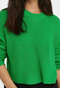 Jasnozielony sweter z dzianiny o luźnym kroju, prążkowanej teksturze i szerokim dekolcie, z opadającymi ramionami i długimi rękawami.