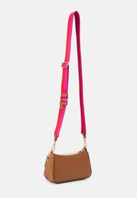 Brązowa skórzana torba na ramię o zaokrąglonym kształcie, wyposażona w żywiołowy różowy regulowany pasek oraz złote elementy metalowe.