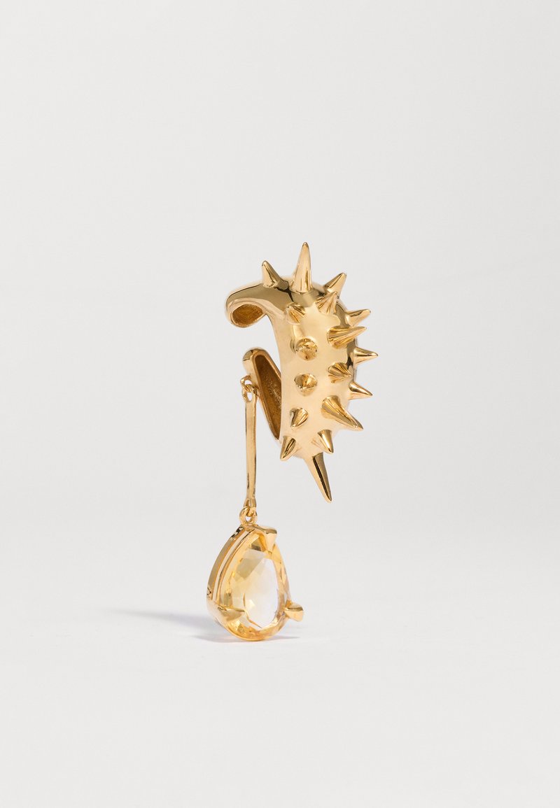 Orecchino a cerchio d'oro con molteplici punte e un unico pendente a forma di goccia con una gemma gialla.