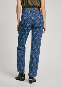 Džíny s vysokým pásom, modré riflové s kvetinovým vzorom, rovný strih a bledý vzhľad, s hnedou koženou nášivkou na zadnej strane.