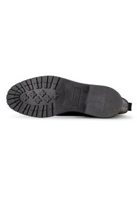 Suela de zapato de goma negra con un patrón de banda de rodadura profunda para tracción, con surcos estampados y un diseño resistente para la durabilidad.