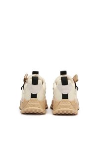 Beżowe i kremowe sneakersy z teksturowaną gumową podeszwą, czarnymi i brązowymi akcentami oraz pętlami na pięcie ułatwiającymi zakładanie.