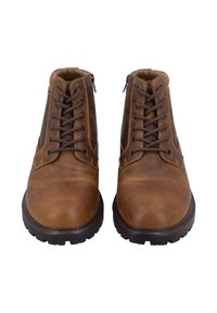 Paar brauner Leder-Schnürstiefel mit dicken Gummisohlen, von vorne auf weißem Hintergrund gesehen.