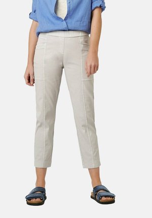 Light gray cropped pants with side pockets, textured fabric, and stitched seams. Paired with navy sandals featuring two straps.