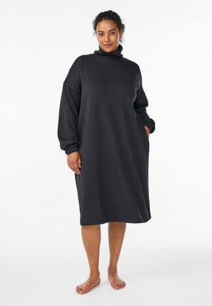 Black sweatshirt dress with a turtleneck, dropped shoulders, long sleeves, side pockets, and a loose, relaxed fit. Soft fabric texture.