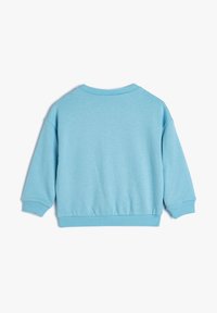 Sudadera azul claro con cuello redondo, puños y dobladillo acanalados, y un corte relajado con una textura suave. Se muestra la vista trasera.