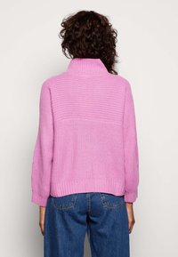 Rosa gestrickter Pullover mit hohem Kragen, gerippten Bündchen und Saum. Verfügt über ein strukturiertes Design auf den oberen zwei Dritteln und einen glatten unteren Bereich.