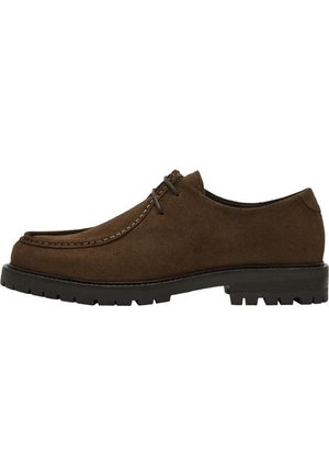 Chaussure en suede marron avec un bout arrondi, des coutures contrastantes, des lacets plats, et une semelle en caoutchouc noir texturé pour une meilleure traction et durabilité.