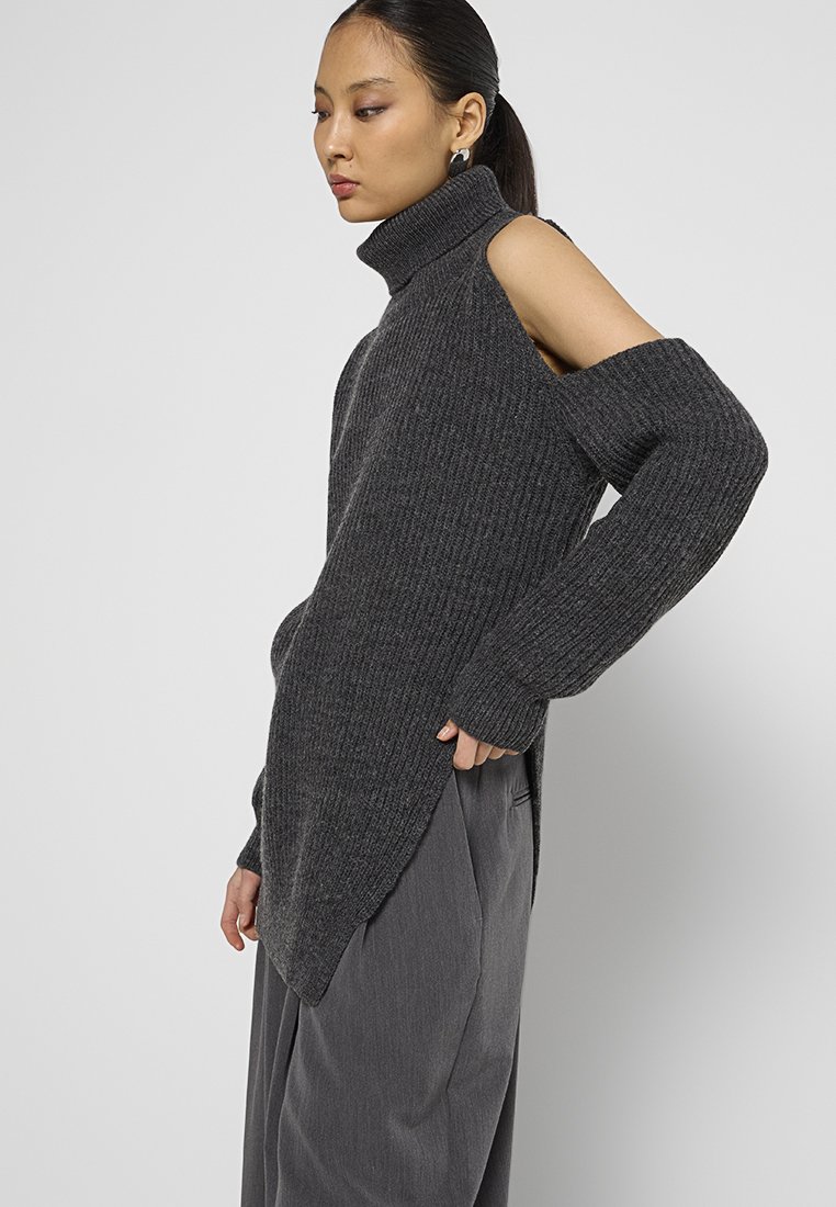 Maglione a coste grigio scuro con collo alto e design con spalle scoperte. Presenta maniche lunghe e orlo asimmetrico. Tessuto a maglia morbido.