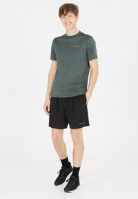Grå atletisk t-shirt med korte ærmer, parret med sorte atletiske shorts. Begge beklædningsgenstande har en logo-detalje og er designet til komfort.
