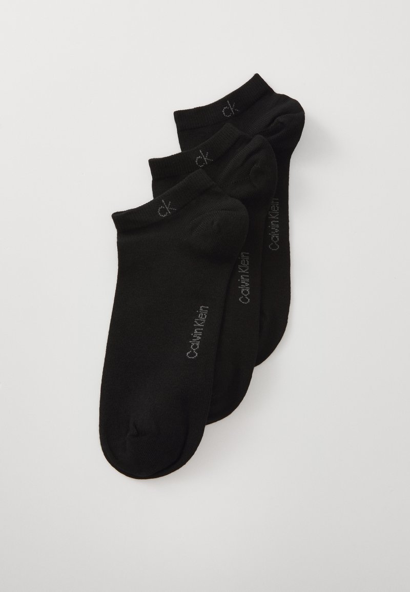 Schwarze Knöchelstrümpfe aus einem weichen Stoff, mit einem gerippten Bündchen und einem grauen "Calvin Klein"-Logo, das an der Seite aufgedruckt ist. Set aus drei Paaren.