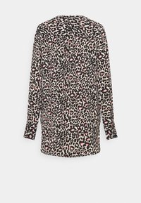 Blus med långa ärmar i svart och rosa leopardmönster, knäppning vid ärmsluten och en rynkad ok på övre delen av ryggen.