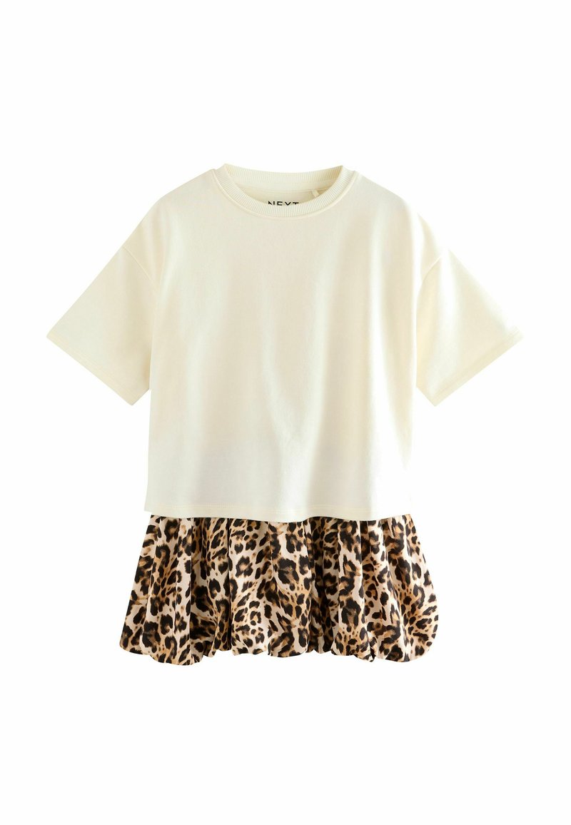 T-shirt à manches courtes avec un haut en coton crème et un bas en coton avec un volant imprimé léopard. Coupe décontractée avec un col rond.