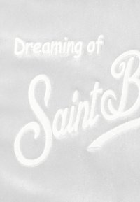 Tissu blanc présentant un texte brodé « Dreaming of Saint B » en police cursive décorative, texture douce avec une finition lisse.