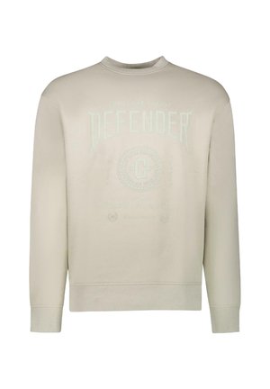 Beige sweatshirt, ronde hals, met reliëftekst "DEFENDER" en circulair logo-detail op de borst. Zachte katoenmix materiaal, geribde manchetten.