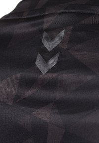 Černá sportovní látka s geometrickým vzorem a dvěma texturovanými chevronovými designy v kontrastní barvě na povrchu.