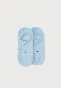 Φωτεινά γαλάζιες κάλτσες τύπου no-show με ραβδώσεις και μικρό κόκκινο, λευκό και μπλε λογότυπο σε κάθε ζευγάρι, τοποθετημένες επίπεδα σε λευκό φόντο.