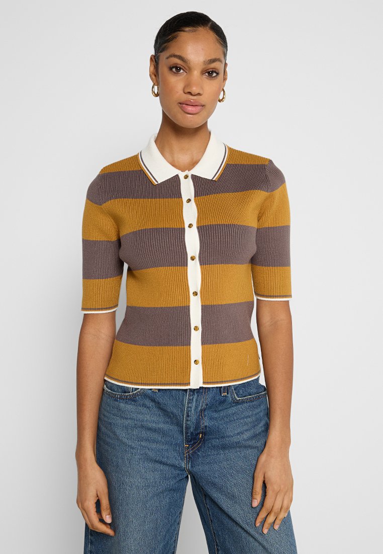 Cárdigan de polo de punto con mangas cortas, con rayas verticales en marrón y mostaza, cierre de botones y un cuello blanco.