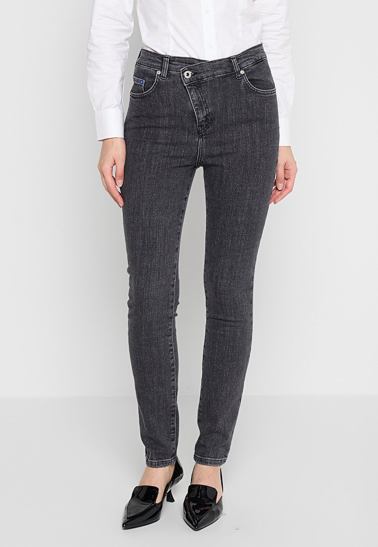 Jeans skinny gris en denim, avec un design classique à cinq poches, un bouton en métal et des coutures contrastées. Texture lisse.