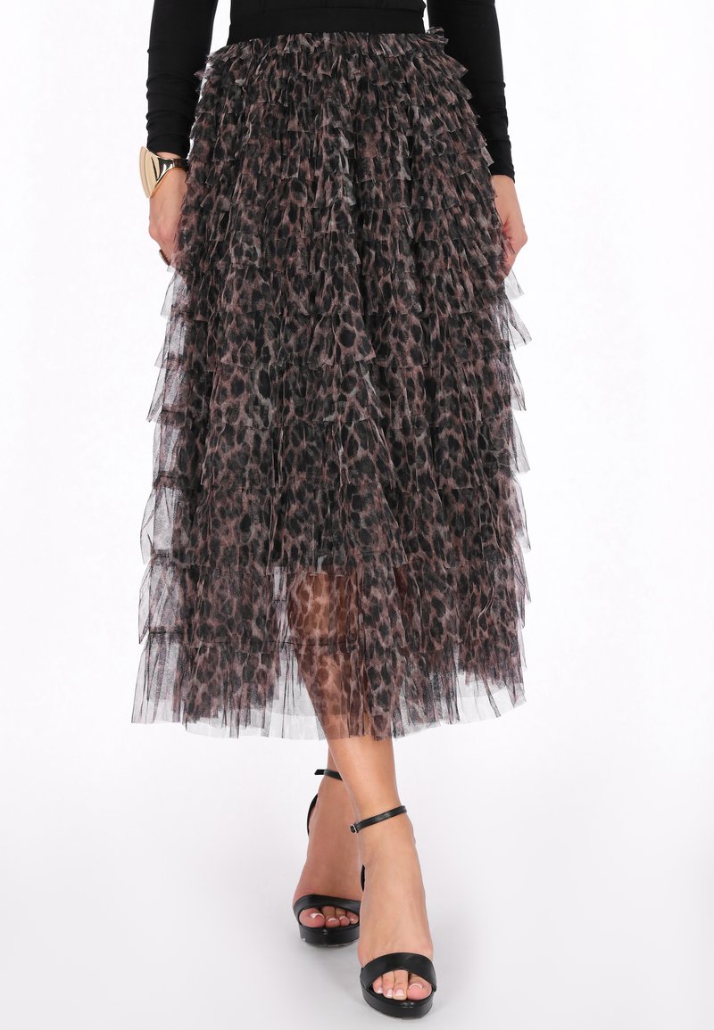 Leopardprint tulle nederdel med lagdelte flæser, midt på læggen, med en sort talje. Modellen har strappy sorte hæle på.