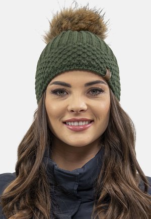 Green knitted beanie hat featuring a textured pattern and a brown faux fur pompom on top. Brown leather patch accent included.
