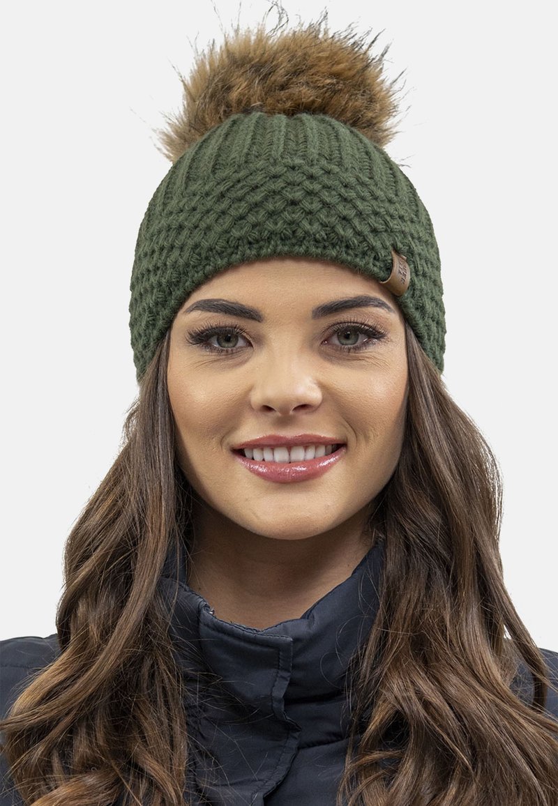 Groene gebreide beanie met een gestructureerd patroon en een bruine nepbont pompon bovenop. Inclusief een bruin leren label als accent.