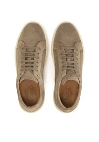 Beige Wildleder-Sneaker mit niedrigem Profil, runder Zehenpartie, sechs Ösen und einer weißen Gummisohle. Das Innenfutter besteht aus braunem Leder.