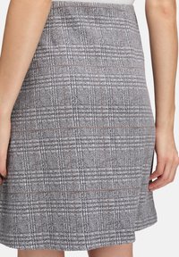 Grijze ruitjespencilrok met een getailleerde pasvorm, subtiele textuur en oranje accenten in het patroon. Gladde stof en een ongeversierde zoom.