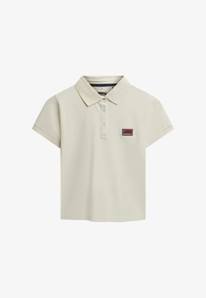 Lys beige polo skjorte med en kort, afslappet pasform, som har en ribbet krave og en lille logo-patch på venstre bryst.