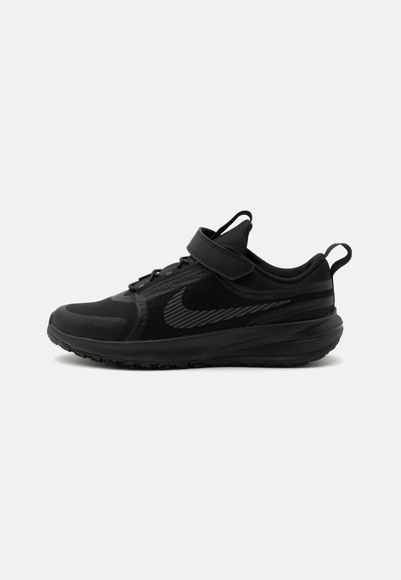 Μαύρο αθλητικό παπούτσι με το λογότυπο της Nike, πλεκτό πάνω μέρος, velcro λουράκι και υφασμένο πέλμα, εμφανίζεται σε πλευρικό προφίλ σε λευκό φόντο.