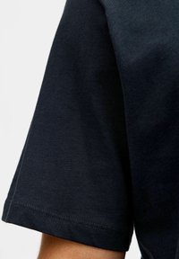Donkerblauwe katoenen T-shirt met een ronde hals, korte mouwen en subtiele stiksels aan de zoom; gladde textuur, casual ontwerp.