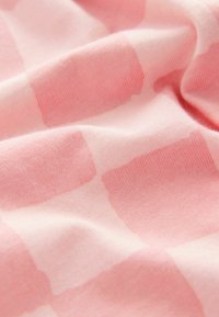 Tela de algodón rosa con una textura suave, que presenta un patrón a cuadros en diferentes tonos de rosa y sutiles degradados.
