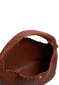 Brown woven leather bag with a rounded shape and a smooth interior. Features a braided handle and minimal gold hardware accents.