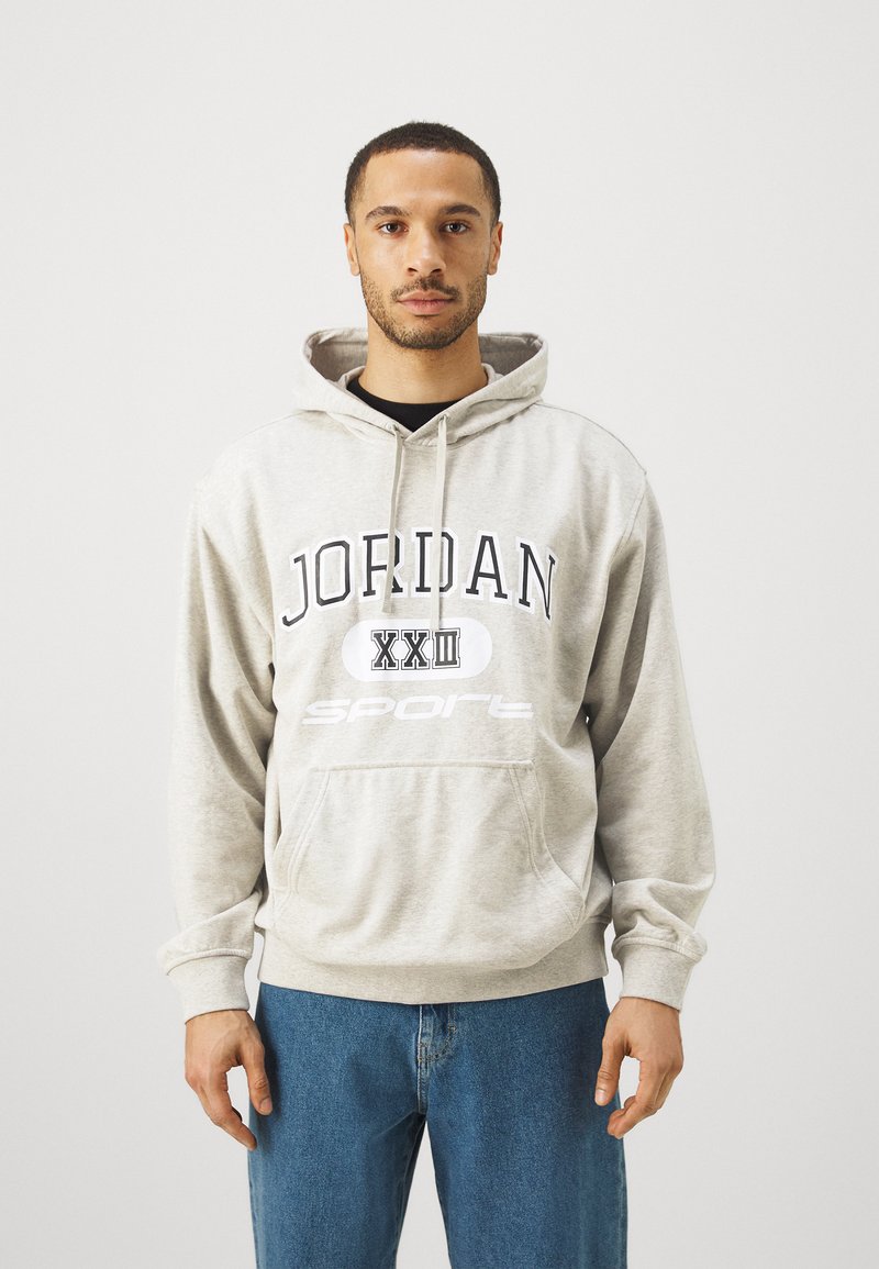 Grauer Kapuzenpullover mit dem Aufdruck "JORDAN XXII SPORT" in Schwarz-Weiß. Hergestellt aus weichem Stoff, verfügt über eine Fronttasche und eine verstellbare Kapuze mit Kordelzug.