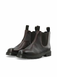 Botas Chelsea de cuero marrón con acabado texturizado, laterales elásticos y suelas de goma. Altura hasta el tobillo con lengüetas para facilitar el uso.