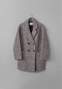 Grå ullkappa med en texturerad yta, dubbelknäppt design, slagkrage och två framfickor. Hänger mot en grå bakgrund.