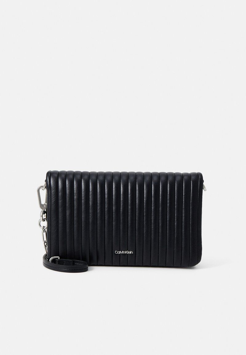 Clutch de couro preto com textura ribete vertical, apresentando um detalhe em metal prateado e faixa destacável. Logotipo em relevo na parte da frente.
