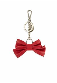 Czerwony skórzany brelok w kształcie kokardki z metalowym łańcuszkiem, pierścieniem na klucze i klipsem na białym tle.