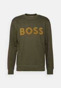 Sudadera verde oliva con cuello redondo y puños acanalados, que presenta un gran texto amarillo "BOSS" en la parte frontal. Textura de tela suave.