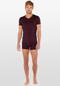 Burgundowa dopasowana koszulka typu V-neck w parze z dopasowanymi slipami, oba wykonane z miękkiego materiału, gładkiej tekstury i minimalistycznego designu.