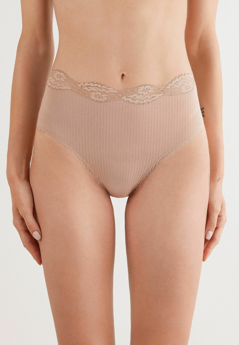 Beige hoge taille slips van ribstof, met een scalloped kantafwerking bij de taille en een gladde afwerking.