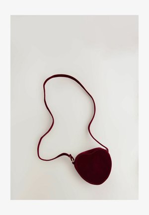 Hjerteformet bordeaux ruskind crossover taske med en tynd strop og synlige syninger. Glat tekstur med et minimalistisk design.