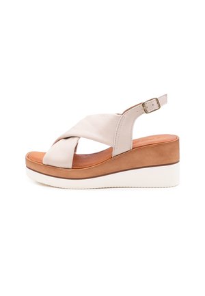 Sandali con zeppa in pelle beige, con fasce incrociate, fibbia regolabile e suola stratificata in marrone e bianco. Sottopiede testurizzato.