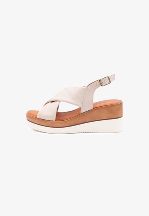 Sandali con zeppa in pelle beige, con fasce incrociate, fibbia regolabile e suola stratificata in marrone e bianco. Sottopiede testurizzato.