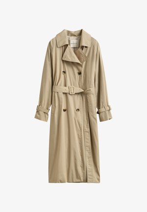 Gabardina beige de doble botonadura con cinturón y correas con hebilla en las mangas largas, con cuello clásico y dos bolsillos delanteros.