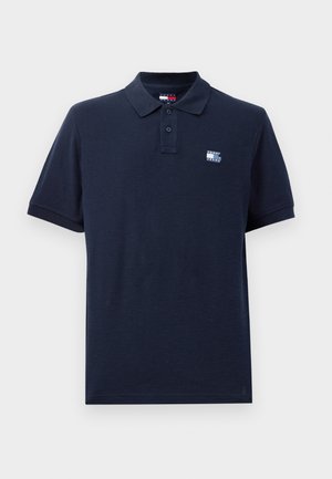 Mørkeblå polo skjorte laget av teksturert bomull, med en tre-knapp placket og en liten logo på venstre bryst. Korte ermer.